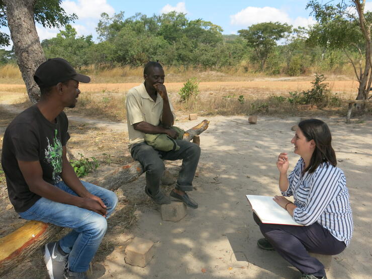 Kelvin Tambulukani (links) und Simona Stoll (rechts) führen mit dem Bauern Moses Sebele (mitte) ein Interview über Umweltbedingungen und Zukunftsvisionen durch.