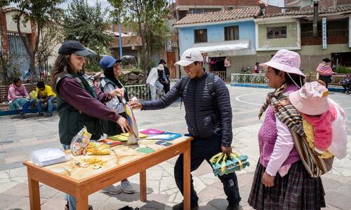 Die Comundo-Fachperson Lucia Tellez engagiert sich in Peru für den Umweltschutz. An einem Stand sensibilisieren Lucia Tellez und junge Umweltaktivisten für einen verantwortungsvollen Umgang mit Abfall.