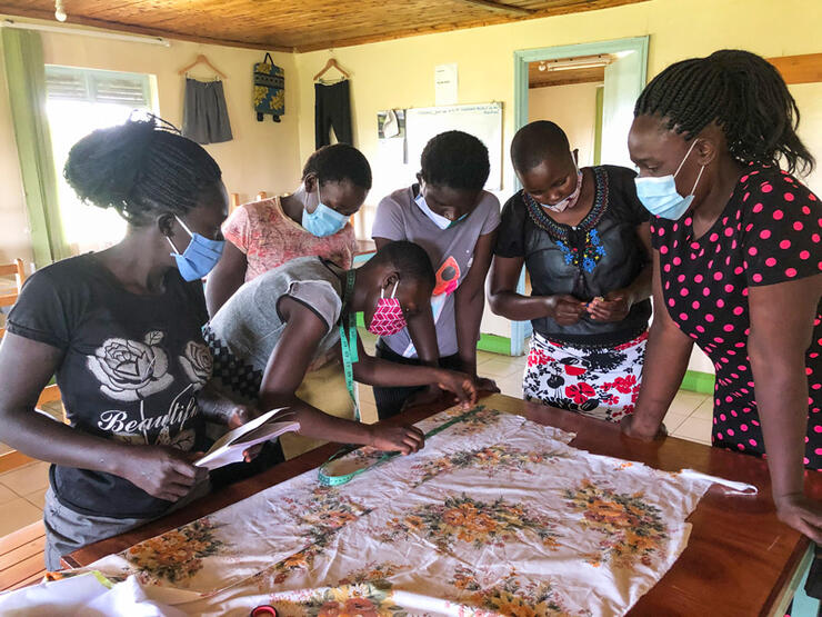 La coopérante locale Mercy Odero (masque facial rose) avec des femmes en formation au centre d'artisanat de Make Me Smile.