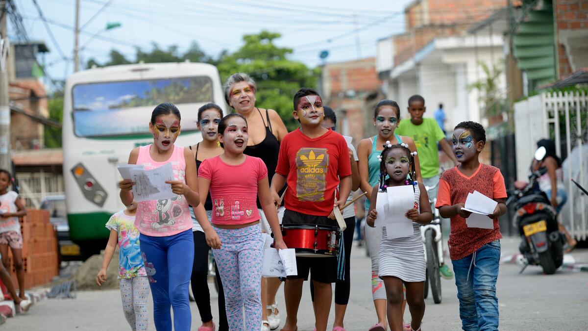 La cooperante Alicia Tellez insieme alle bambine e ai bambini di Aguablanca, Colombia