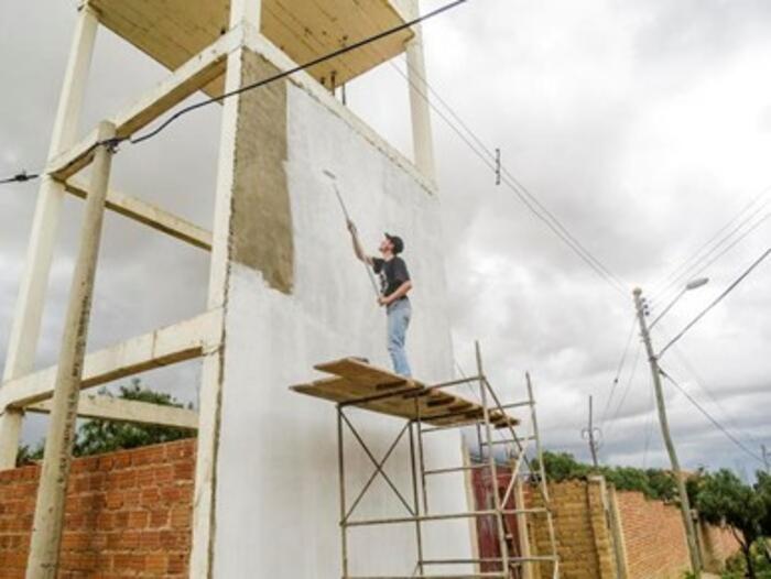 In einem Vorort von Cochabamba streicht Alain die Wand eines Wassertankturms. Auf dieser soll ein Graffiti zum Thema „Wasser“ entstehen.